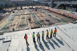 Architects and construction managers collaborating over digital building plans at a job site